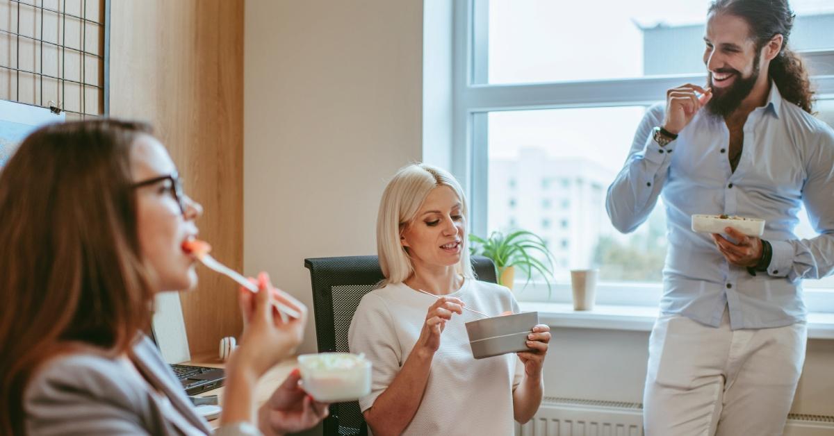 coworkers eating lunch together in the office