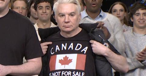Mike Myers holding up a Canada is Not for Sale shirt.