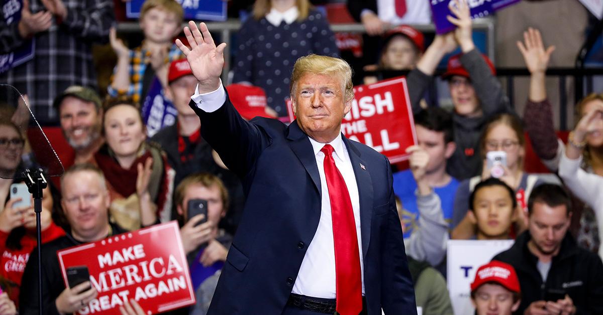 Donald Trump waving to the crowd at a political rally