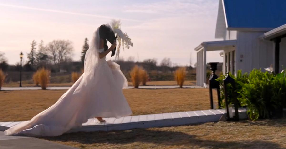 A woman in a wedding dress holds a bouquet of flowers up to cover her face during Season 8 of 'Love Is Blind.'