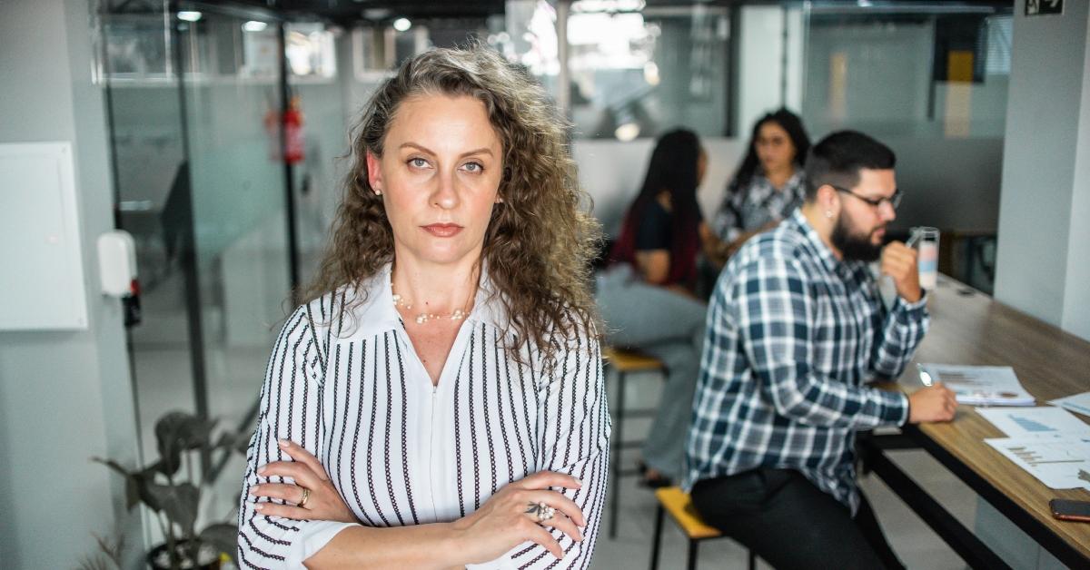 frustrated businesswoman with her arms crossed in office space