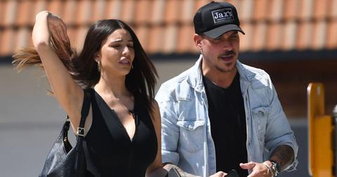 Paige Woolen tosses her hair while walking next to Jax Taylor, who is speaking to her