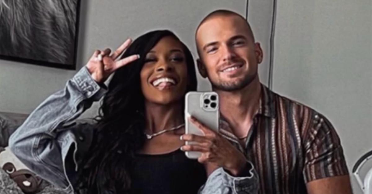 An interracial couple smiling for a photo, as seen in a "Black Wife Effect" TikTok video