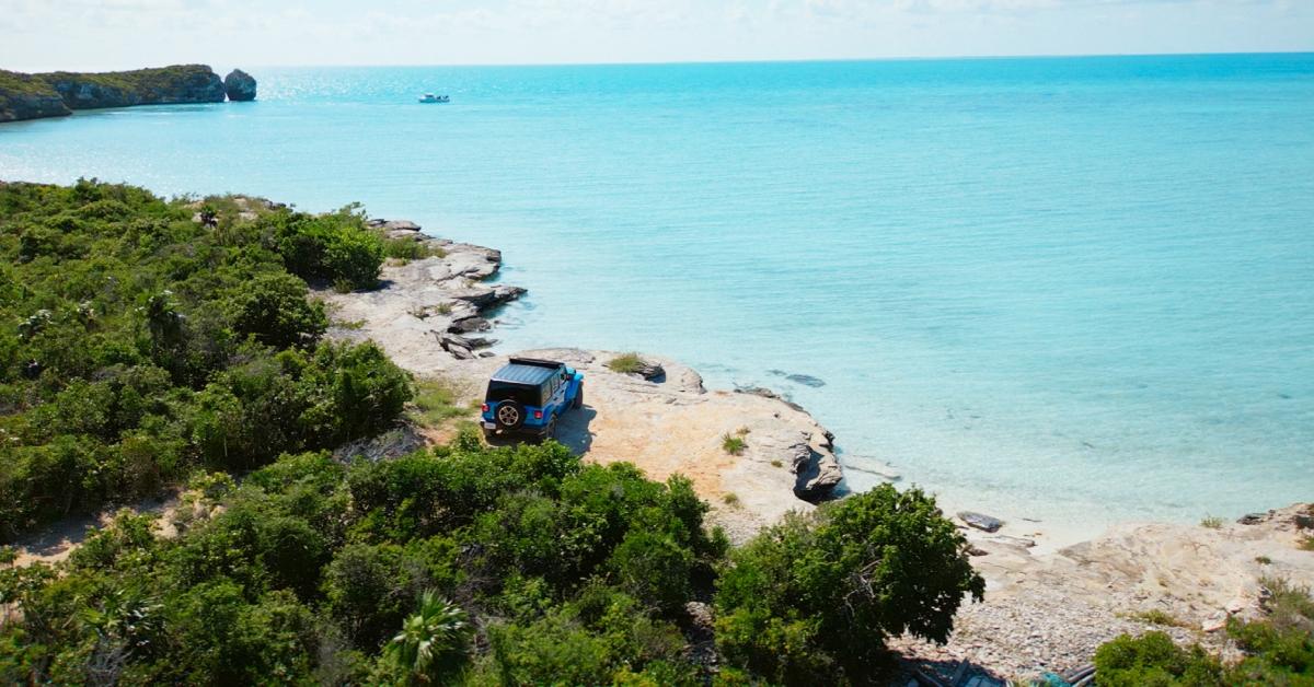 A photo of a blue jeep on a cliff overlooking the ocean in Season 6 of ‘Too Hot to Handle.’