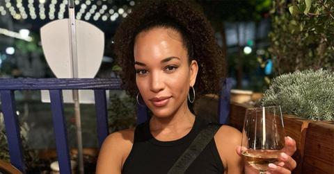 MJ Acosta-Ruiz holding a wine glass at dinner.