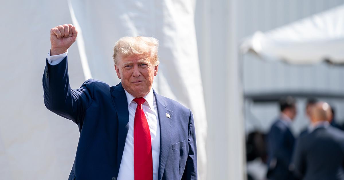 Donald Trump gives a fist pump in a suit and tie. 