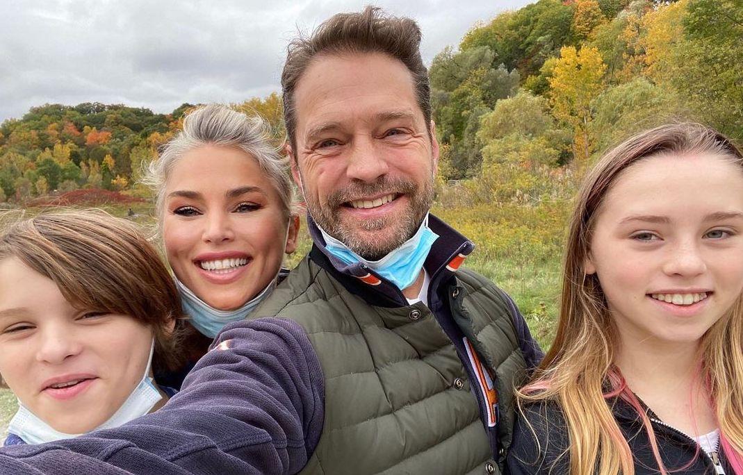 Jason Priestley smiling with his wife and two kids