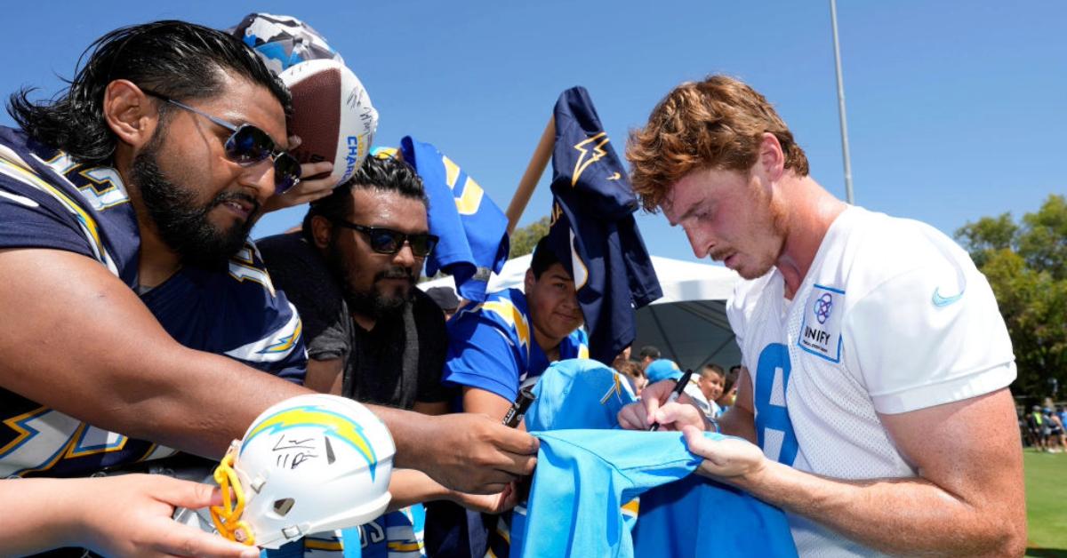 Rookie Quarterback Max Duggan #8 of the Los Angeles Chargers signs a football jersey at Jack Hammett Sports Complex on August 5, 2023 in Costa Mesa, California.