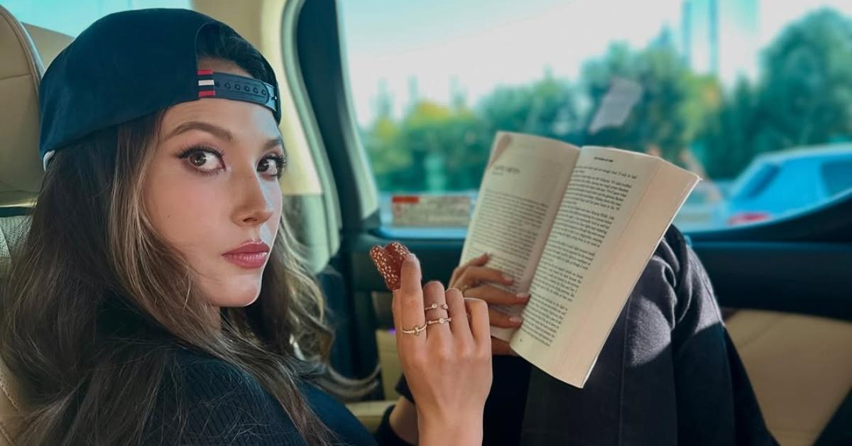 Eileen Gu reading a book in her car.