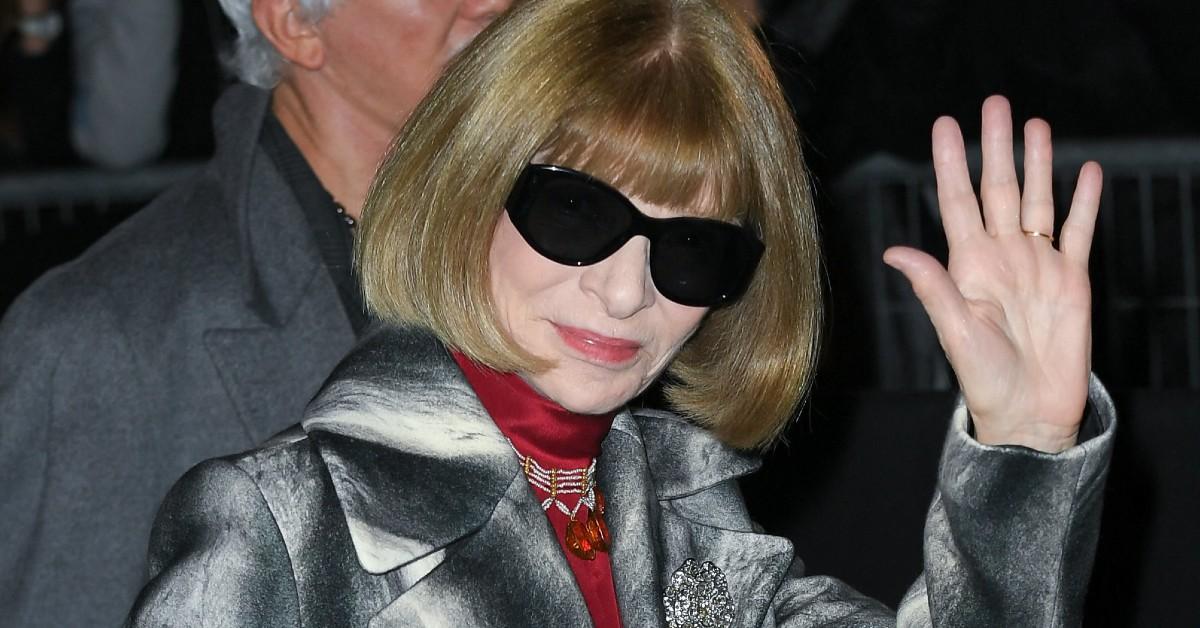 Anna Wintour waves while wearing sunglasses