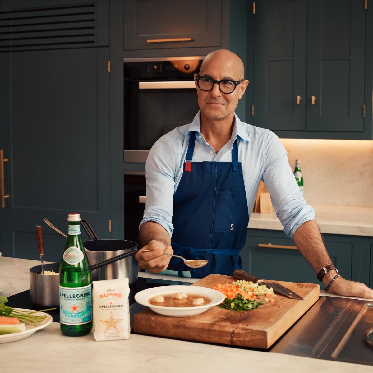 Photo of actor and filmmaker Stanley Tucci in a kitchen with his S.Pellegrino 2023 recipe kit