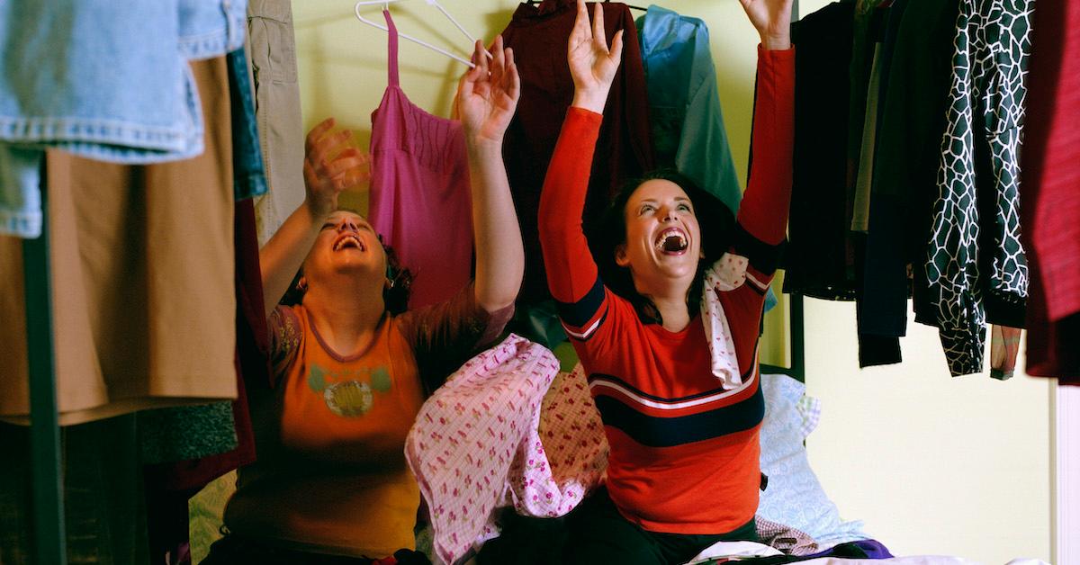 Women on bed throwing clothing - stock photo