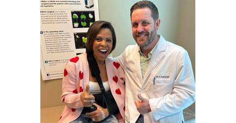 Laura Harris gives a thumbs up next to a doctor.