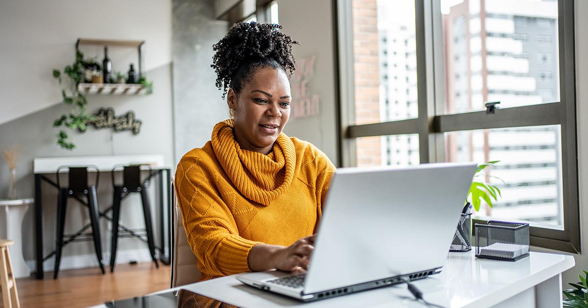 A woman typing and looking at a computer screen. 