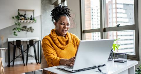 A woman typing and looking at a computer screen.