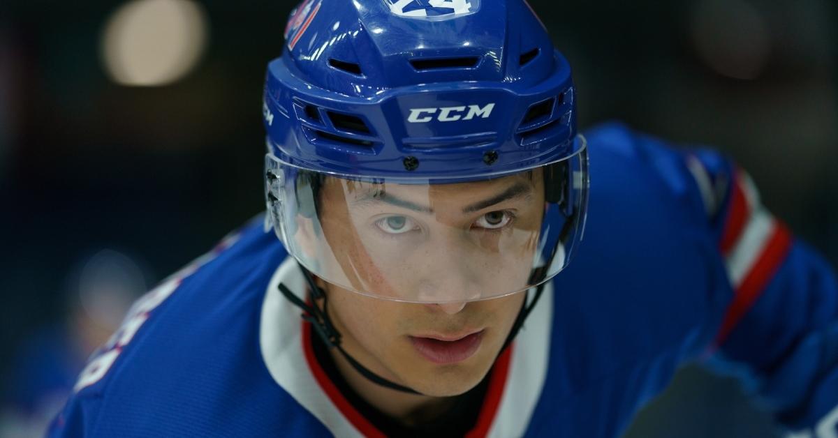 Hudson Williams's character gets ready to take a shot in the show Heated Rivalry.