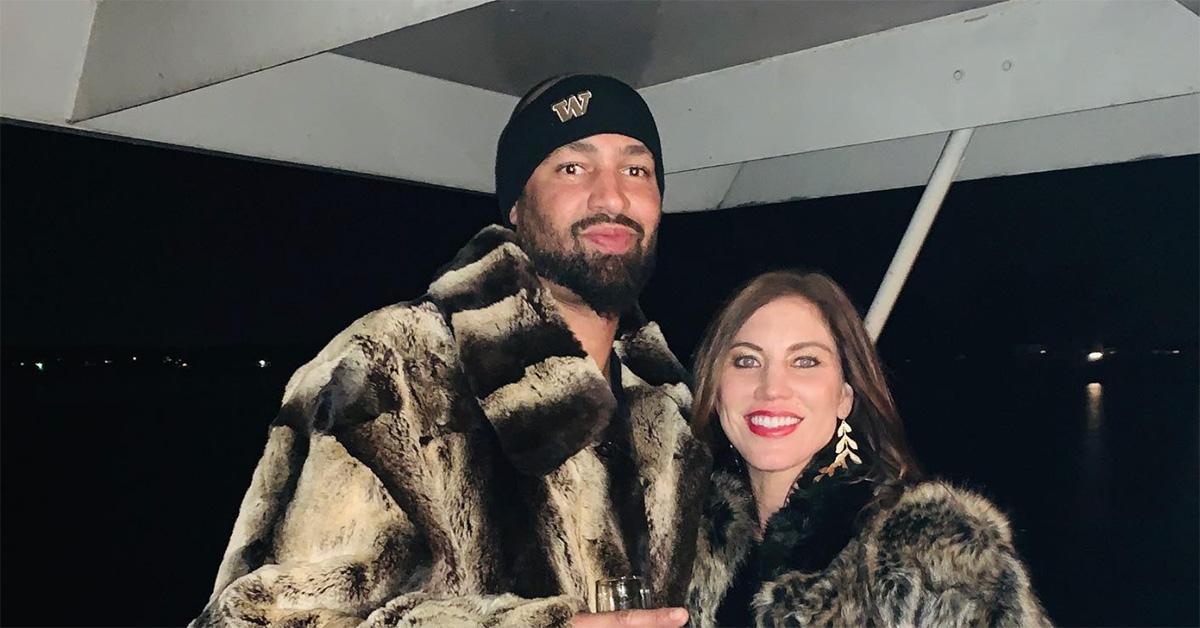 Jerramy Stevens and Hope Solo in fur coats on a boat. 