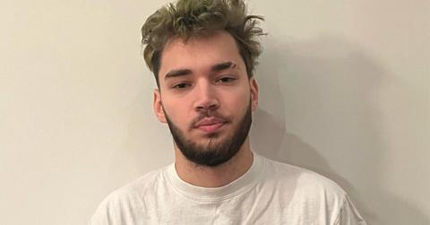 Adin Ross with a beard and a white t-shirt.