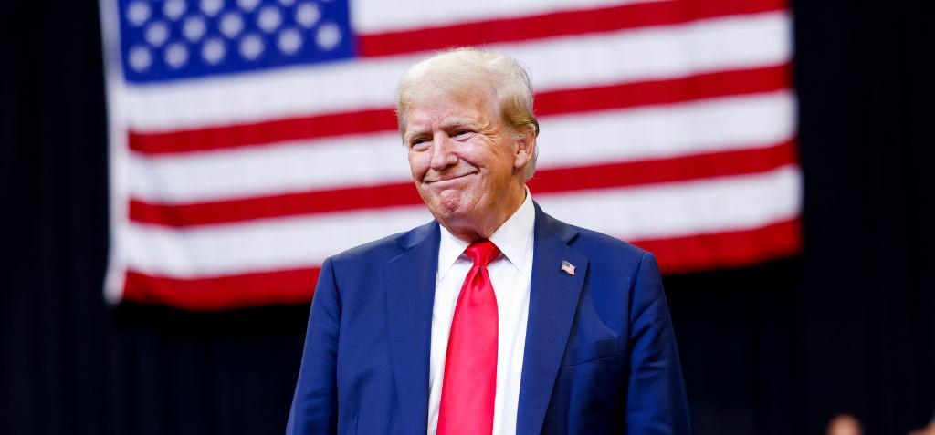 Trump standing in front of the American Flag