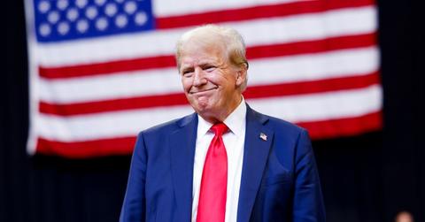 Trump standing in front of the American Flag