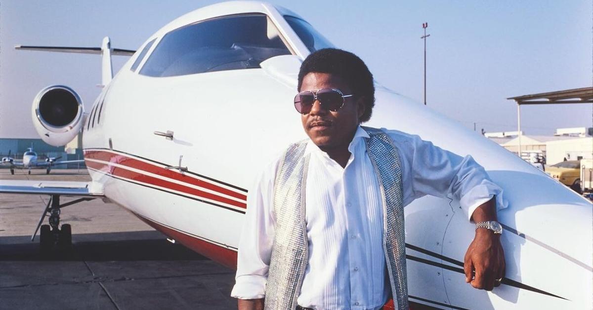 Tito Jackson stands in front of a plane