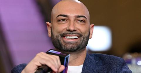 John Fuda holding a microphone and smiling