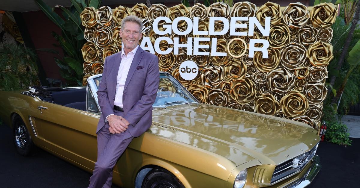 'The Golden Bachelor' leading man Gerry Turner dons a purple suit while leaning on a gold convertible at an event.