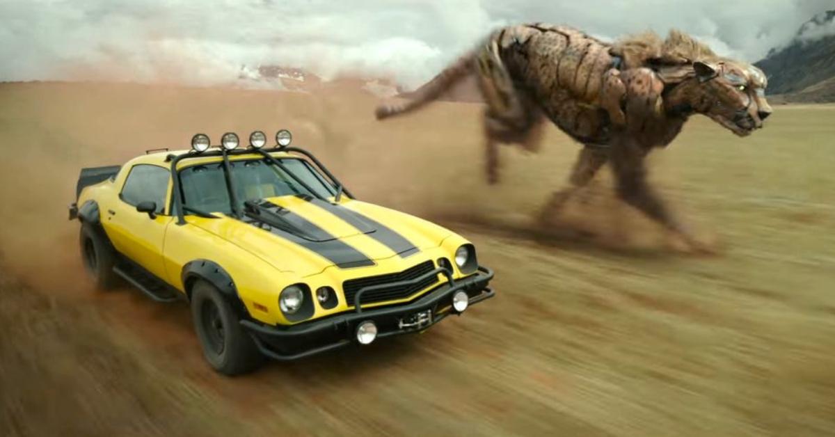 Yellow car driving alongside a cheetah maximal  in the desert in the 'Transformers: Rise of the Beasts' 