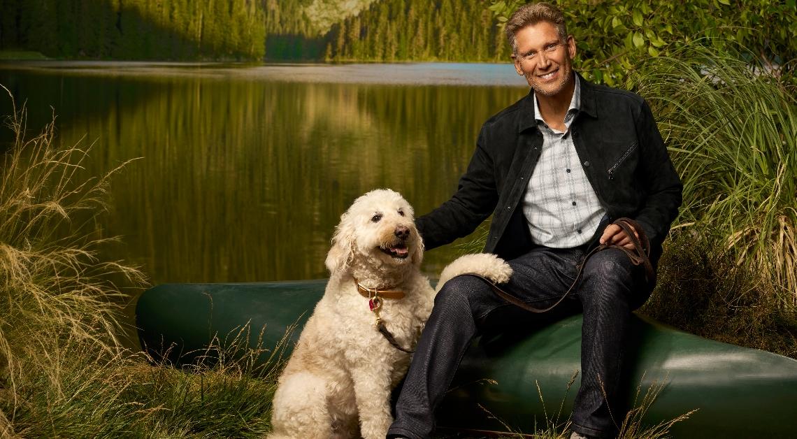 Gerry Turner sits on a canoe next to a dog