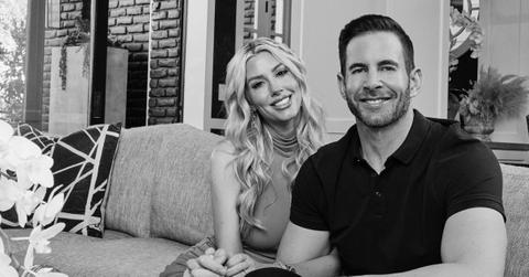 Tarek and Heather El Moussa sitting on a couch
