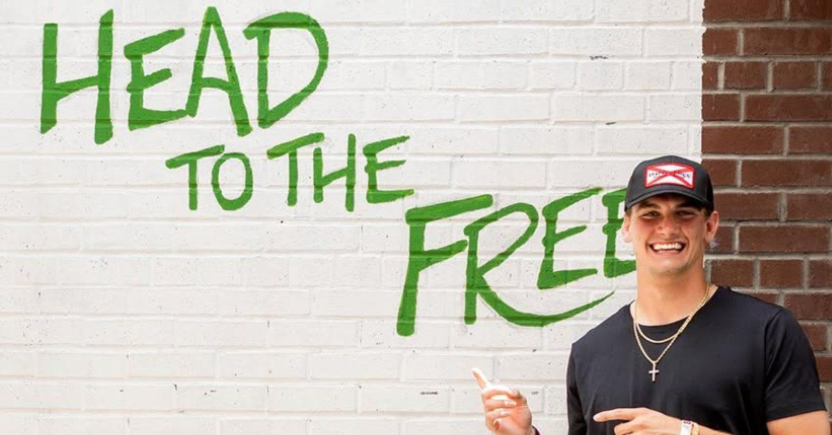 Ty Simpson standing in front of a "Head to the Free" sign.