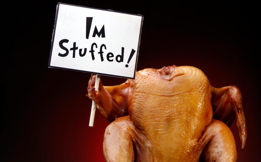 Thanksgiving turkey holding an "I'm stuffed" sign