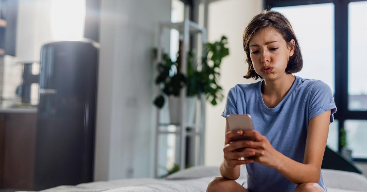 woman looks upset looking at her phone