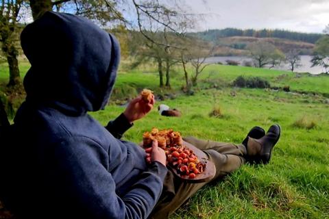 One of the members of men with the pot eating their culinary creation