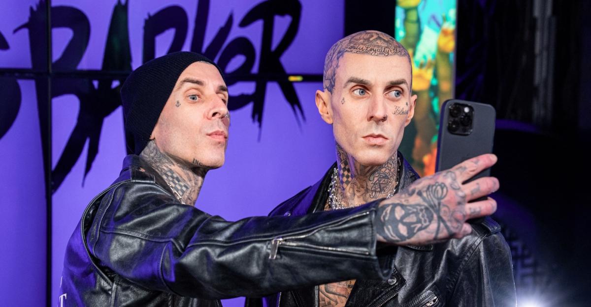 Travis Barker poses with his wax replica