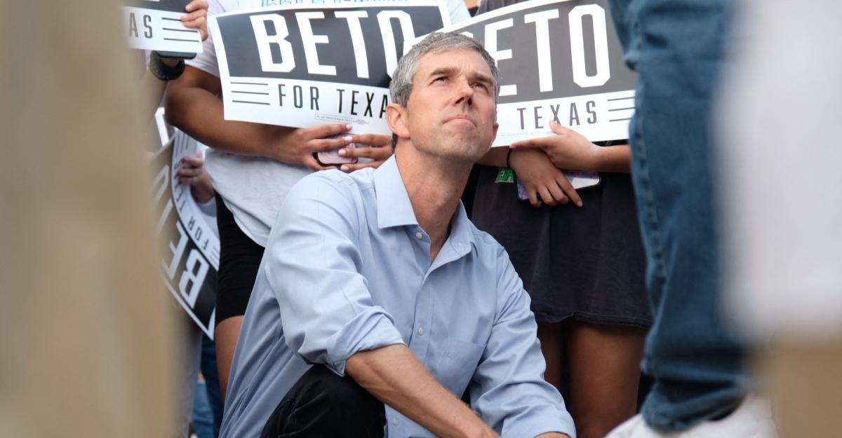 Beto O'Rourke kneels on the ground during his 2019 Texas race.