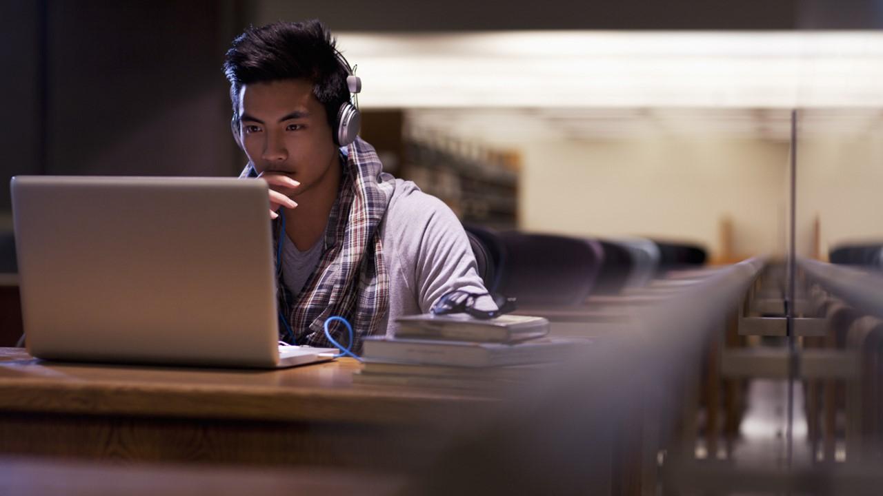 A man looking at Facebook's new logo on his laptop