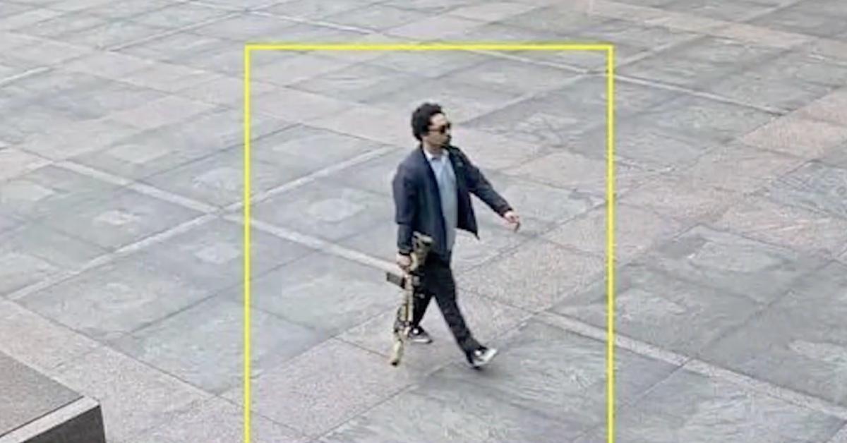 Shane Tamura walking with an M4 assault rifle.