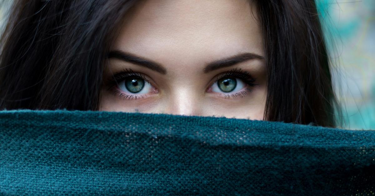 Woman peeking out from behind fabric