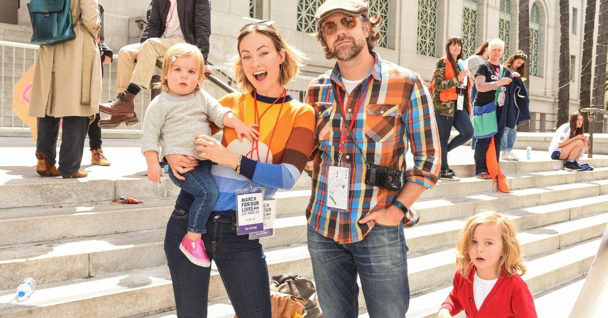 (l-r): Daisy Sudeikis, Olivia Wilde, Jason Sudeikis, and Otis Sudeikis smiling outside. 