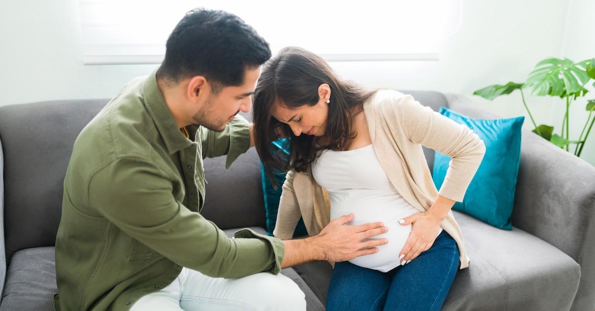 A husband cradling his pregnant wife's belly