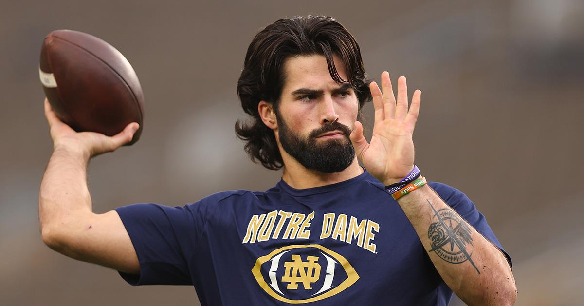 Sam Hartman throwing the football in a Notre Dame t-shirt.