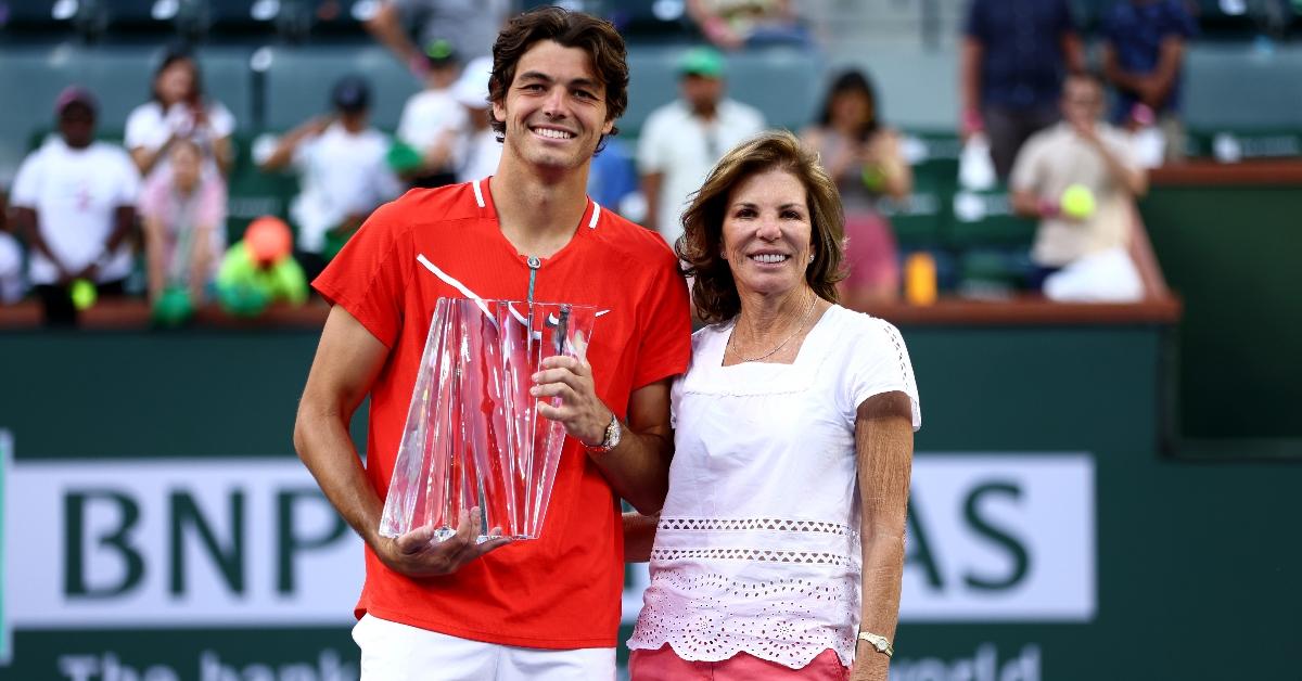 Taylor Fritz of the United States holds his winners trophy with his mother former player Kathy May after his straight sets victory against Rafael Nadal of Spain in the men's Final on Day 14 of the BNP Paribas Open at the Indian Wells Tennis Garden on March 20, 2022 in Indian Wells, California. (Photo by Clive Brunskill/Getty Image)