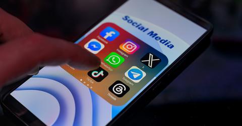 A TikTok app on a phone with a finger.