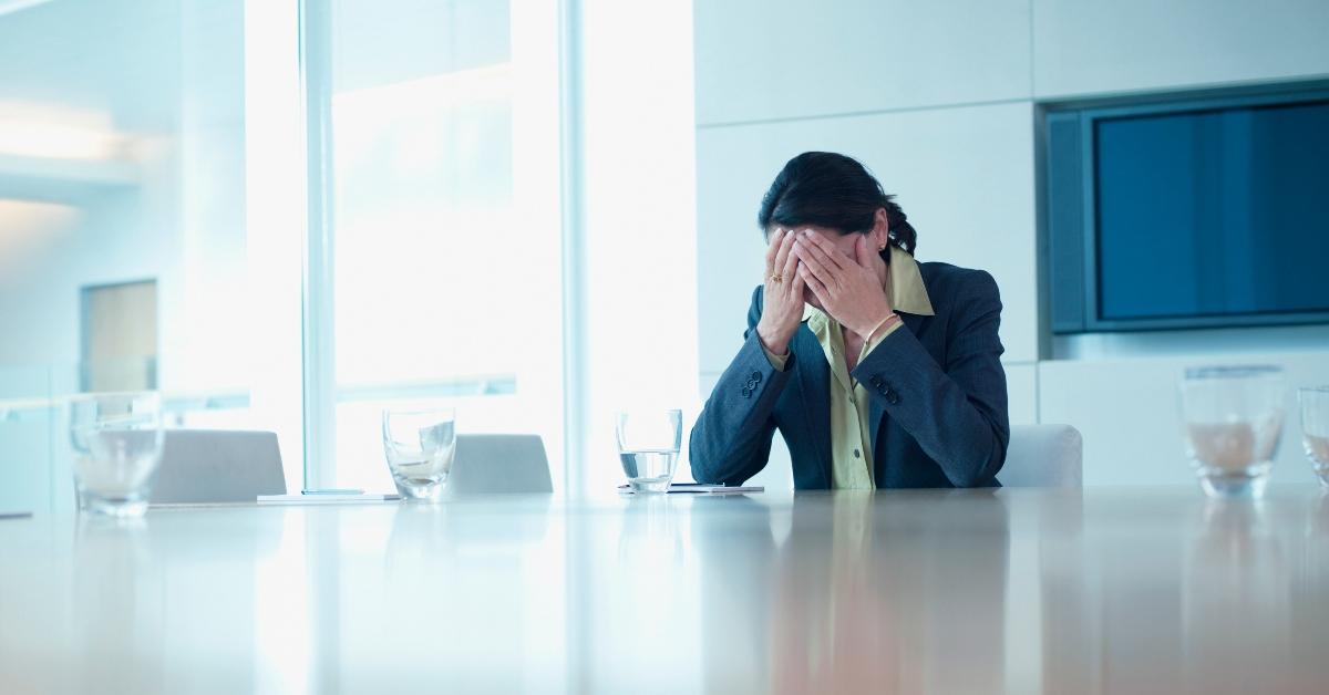 woman upset at her job with her face in her hands