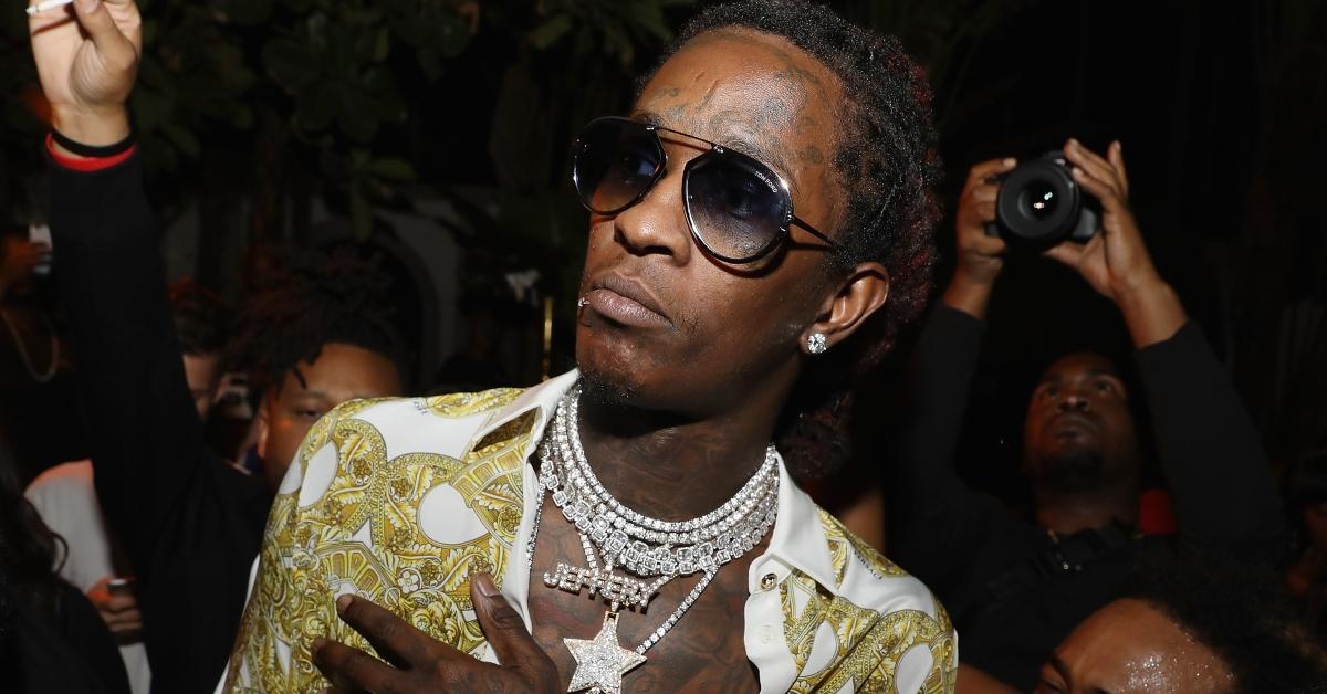 Young Thug at the versace mansion looking disgruntled amid a crowd of papparazo.