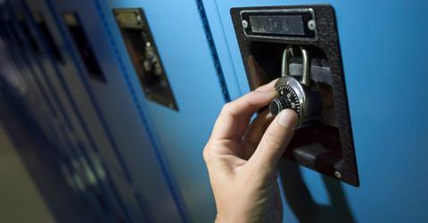 A person opening a combination lock
