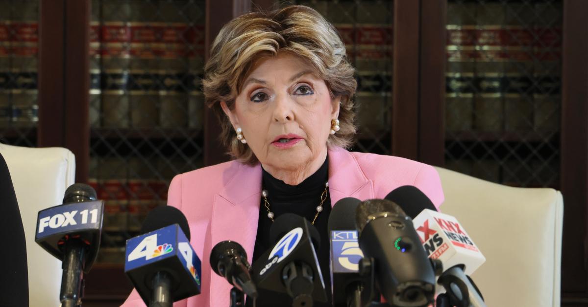 Gloria Allred speaking to the media in a pink blazer.