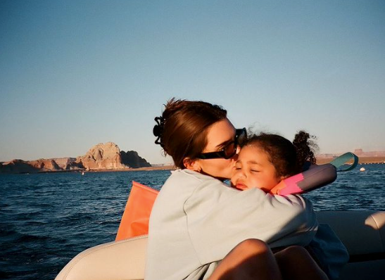 Kendall Jenner kisses one of her nieces on a boat