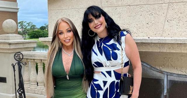 Mary and Brittani wearing dresses by an outdoor fireplace